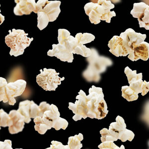 Flying popcorn isolated on black background, movie poster concept