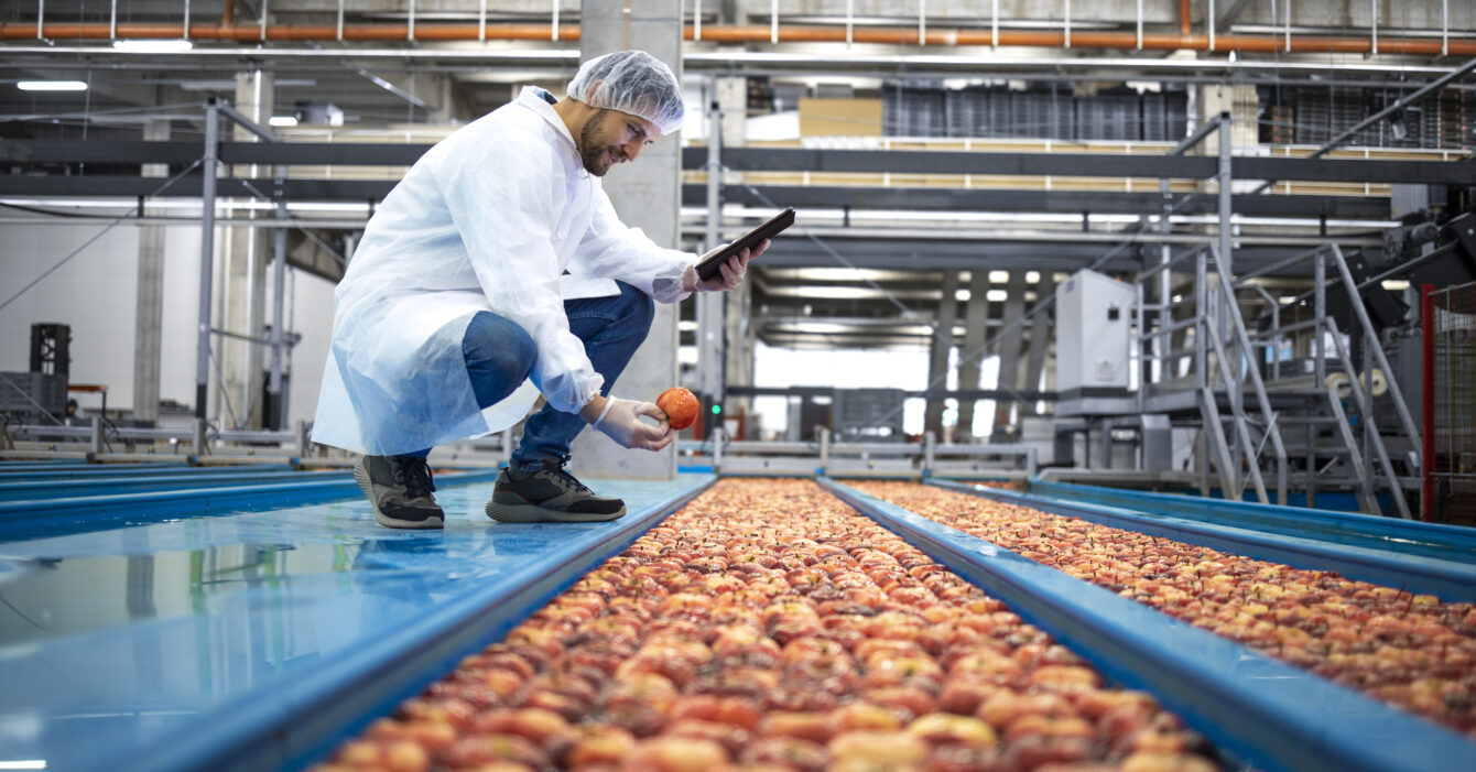 technologist-with-tablet-computer-standing-by-water-tank-conveyers-doing-quality-control-apple-fruit-production-food-processing-plant-1340x701.jpg